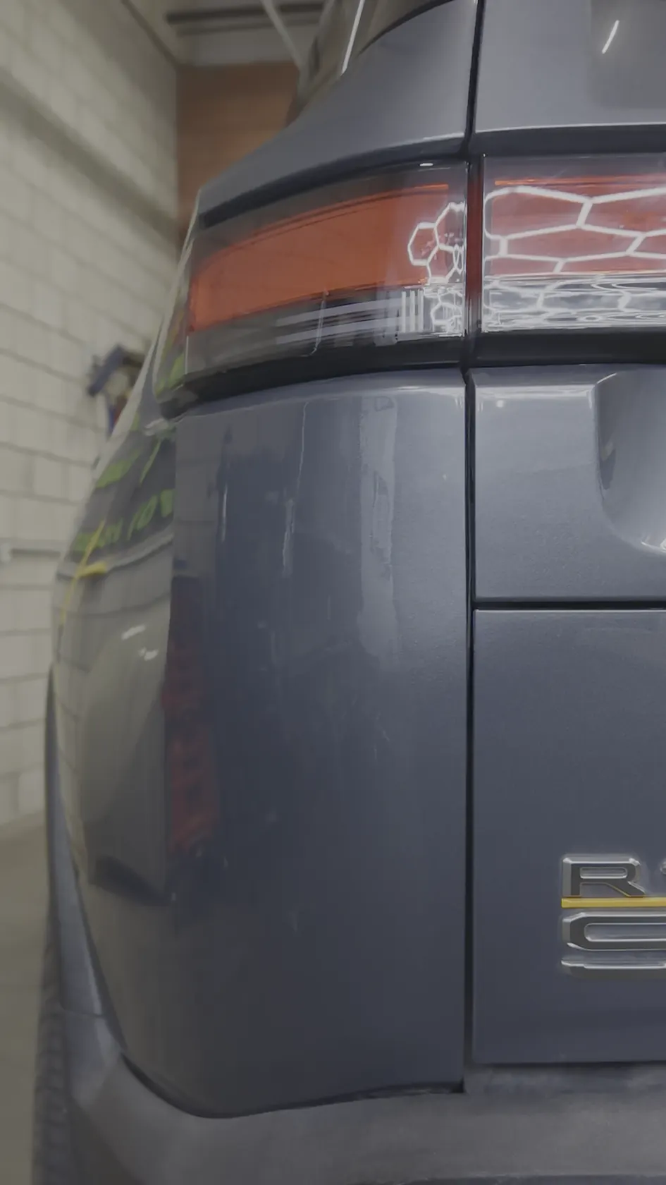 The same 2023 Rivian R1S quarter panel after paintless dent repair — factory paint, no trace of the dent