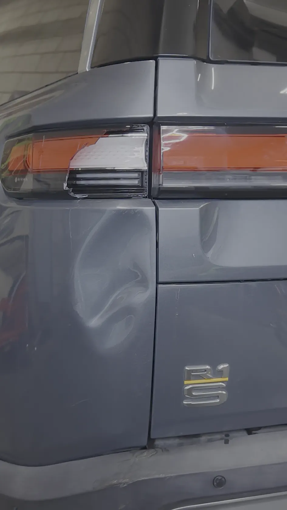 2023 Rivian R1S rear quarter panel with a large dent beside the taillight, before paintless dent repair