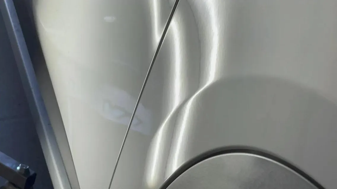 Fender crease being read with a reflection line before paintless dent repair